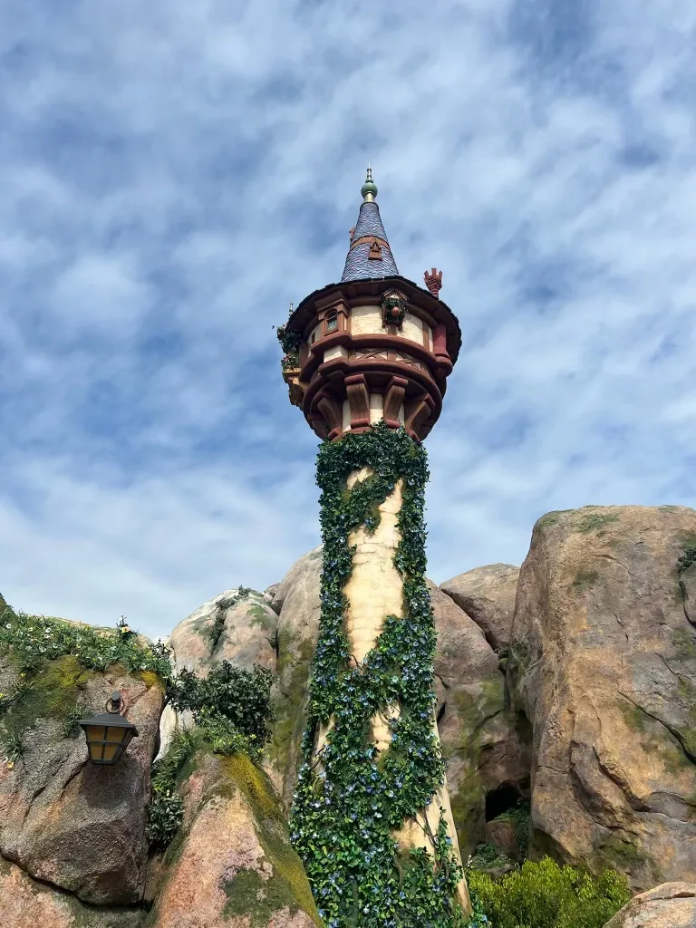 Rapunzel's tower rising from rockwork at Fantasy Springs, Tokyo DisneySea, wrapped in ivy
