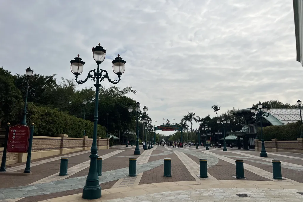 A near-empty entrance walkway at Hong Kong Disneyland under an overcast sky