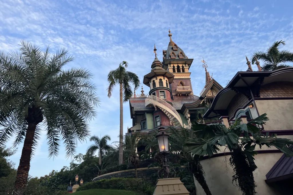 Mystic Manor's ornate exterior among palm trees at Hong Kong Disneyland